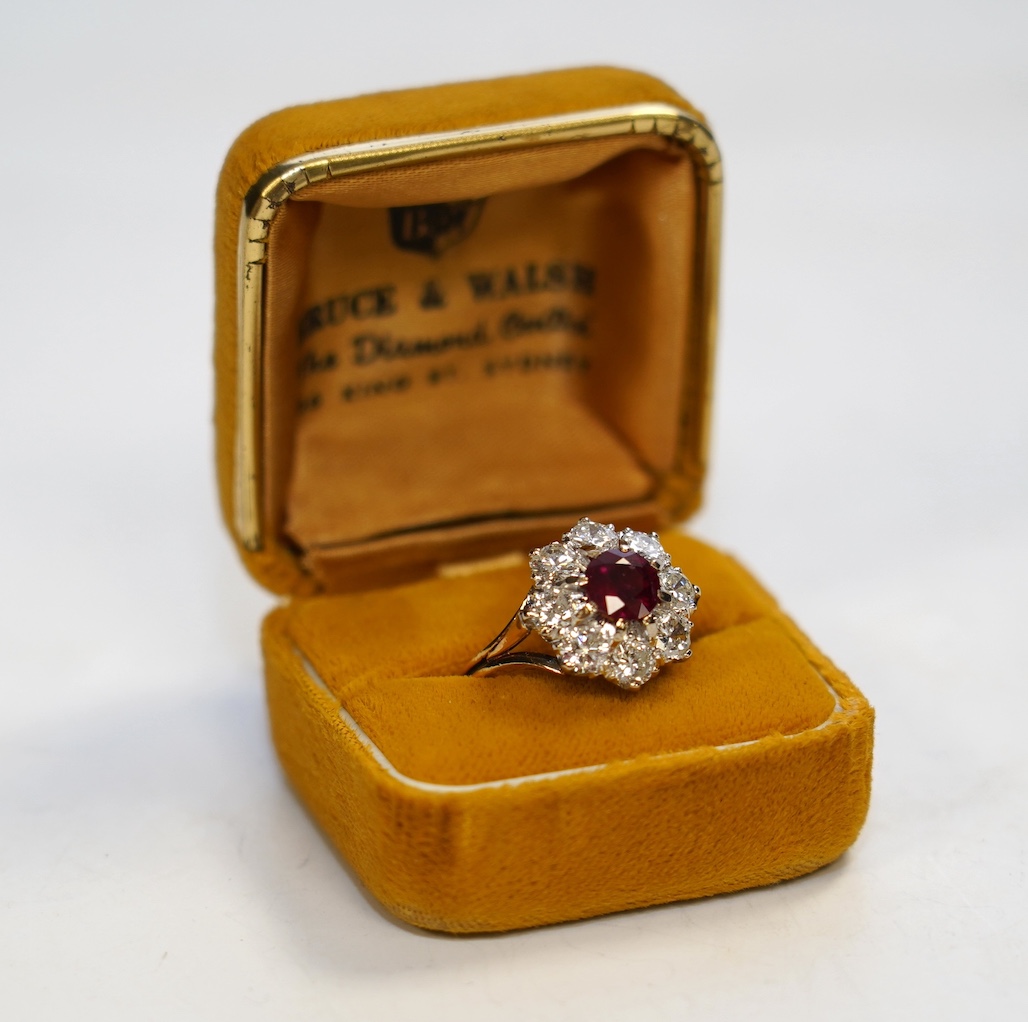 An 18ct gold, single stone ruby and eight stone diamond set flower head cluster ring, size P, gross weight 6.5 grams. Condition - fair